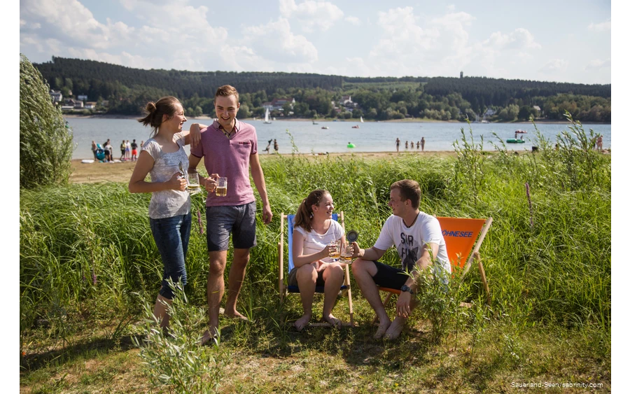 Freunde trinken zusammen ein Bier auf der Liegewiese