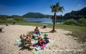 Eine Familie genießt die Sonne auf dem Badestrand am See