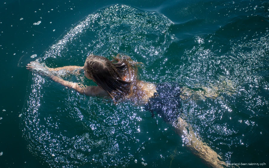 Ein Mädchen schwimmt durch den klaren Sorpesee.