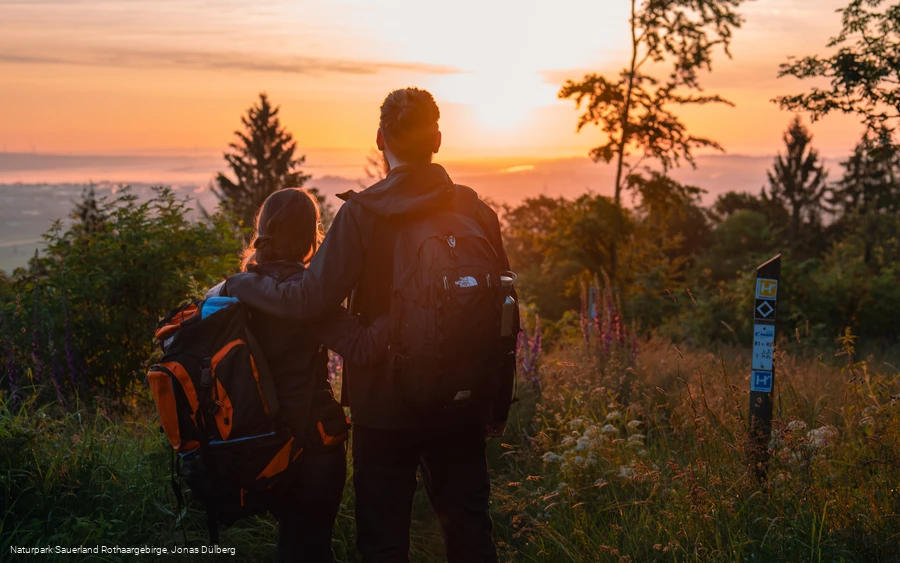 Wanderpaar vor Sonnenaufgang am Eisenberg in Korbach