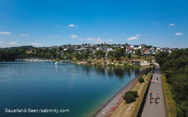 Blick von oben auf See und gut besuchten Damm